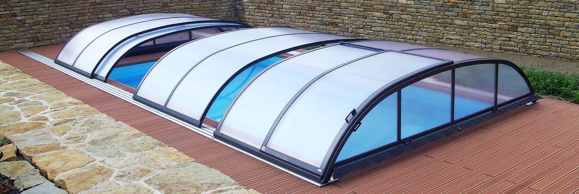 Piscina interrata con copertura semovente in vetro, perfetta per tutto l'anno.