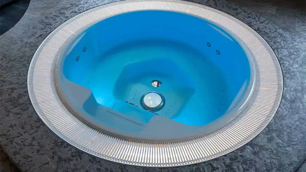 Vasca idromassaggio circolare Roman Public 255 con bordo a sfioro, finitura azzurra e sedute interne ergonomiche