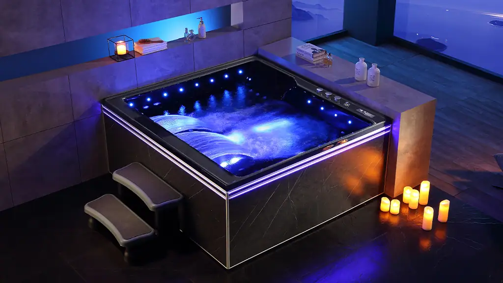 Relaxing hot tub with blue LED lighting, modern black exterior, and small steps in a spa room with candles and amenities, ideal for wellness and relaxation.